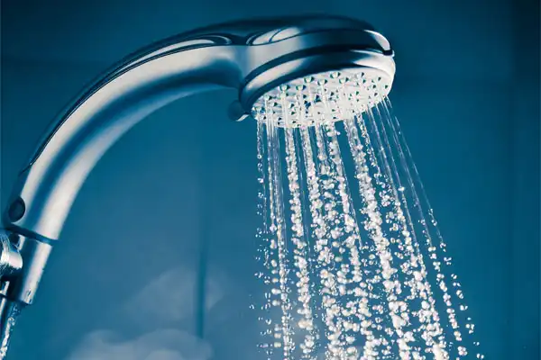 Close-up of a showerhead with multiple streams of water cascading down, set against a blue background.